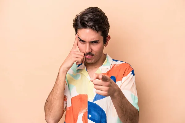 Jovem Caucasiano Isolado Fundo Bege Apontando Templo Com Dedo Pensando — Fotografia de Stock