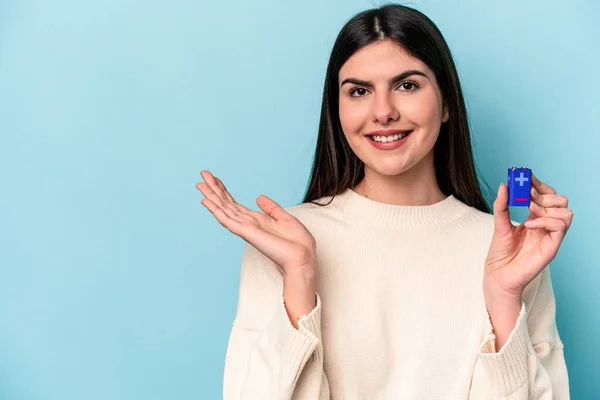 Giovane Donna Caucasica Che Tiene Una Batteria Isolata Sfondo Blu — Foto Stock