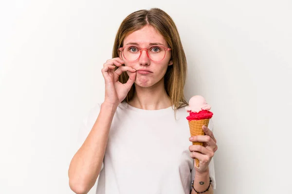 Young English woman holding an ice cream isolated on white background with fingers on lips keeping a secret.