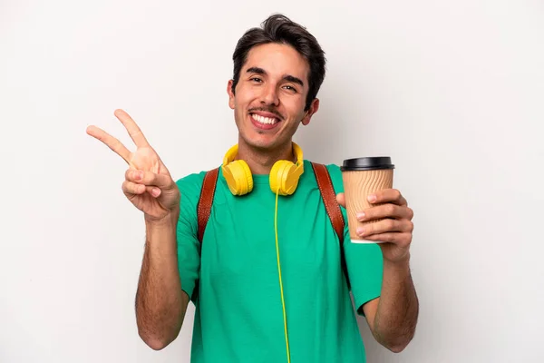 白を基調としたコーヒーを飲む若い白人学生の男喜びと屈託のない指で平和のシンボルを示す — ストック写真