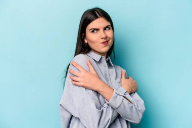 Kafkasyalı genç kadın mavi arka planda izole edilmiş, güler yüzlü ve mutlu..