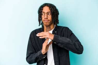 Genç Afrikalı Amerikalı bir adam mavi arka planda izole edilmiş..