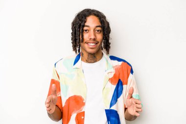 Beyaz arka planda izole edilmiş genç Afrikalı Amerikalı iki eliyle bir şey tutuyor, ürün sunumu..