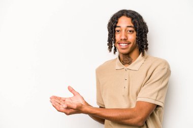 Beyaz arka planda izole edilmiş genç Afro-Amerikalı bir adam bir palmiye üzerinde bir kopya alanı tutuyor..