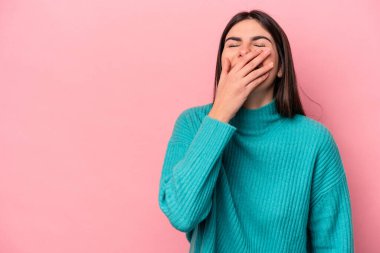 Pembe arka planda soyutlanmış genç beyaz kadın gülüyor, kaygısız, doğal duygu..