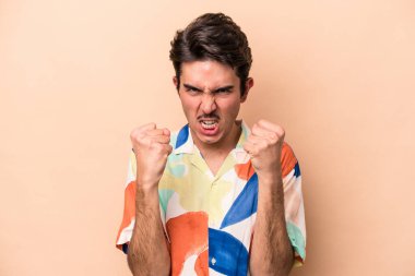 Beyazlı genç adam bej arka planda izole edilmiş gergin elleriyle çığlık atıyor..