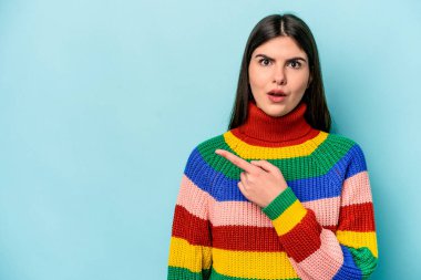 Mavi arka planda izole edilmiş genç beyaz kadın...