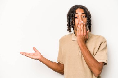 Beyaz arka planda izole edilmiş genç Afro-Amerikalı adam, avuç içi fotokopi alanı tutmaktan etkilenmiş..