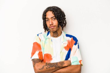 Beyaz arka planda izole edilmiş genç Afrikalı Amerikalı adam alaycı bir ifadeyle kameraya bakıyor..