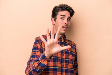 Beyazlı genç bir adam bej arka planda izole edildi. Yakın bir tehlike nedeniyle şoka girdi.