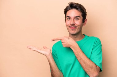 Beyaz tenli genç, bej arka planda izole edilmiş..