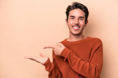 Beyaz tenli genç, bej arka planda izole edilmiş..