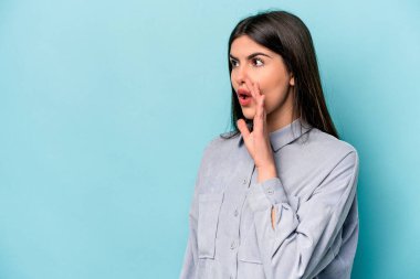 Mavi arka planda izole edilmiş beyaz bir kadın gördüğü bir şey yüzünden şoka uğruyor..