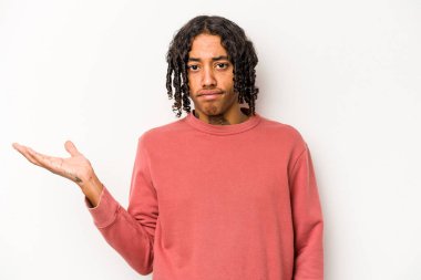 Genç Afrikalı Amerikalı, beyaz arka planda izole edilmiş. Sorgulama sırasında omuz silkiyor ve şüphe ediyor..