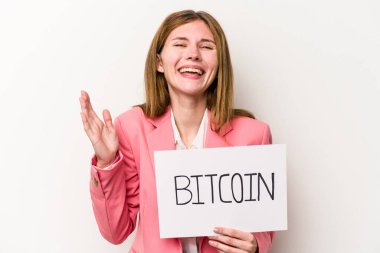Beyaz arka planda izole edilmiş bitcoin pankartı tutan genç bir İngiliz iş kadını hoş bir sürpriz alıyor, heyecanlı ve el kaldırıyor..