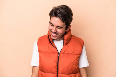 Beyazların arka planında izole edilmiş genç beyaz adam gülüyor ve gözlerini kapatıyor, rahatlamış ve mutlu hissediyor..