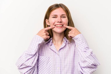 Beyaz arka planda izole edilmiş genç Rus kadın gülümsüyor, parmaklarını ağıza doğrultuyor..