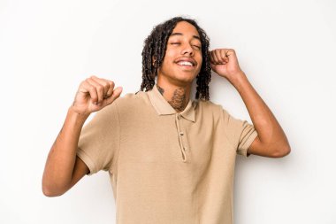 Beyaz arka planda izole edilmiş genç Afrikalı Amerikalı özel bir günü kutluyor, atlıyor ve enerjiyle kollarını kaldırıyor..