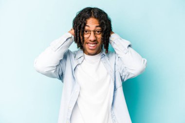 Genç Afrikalı Amerikalı adam mavi arka planda izole edilmiş öfkeyle bağırıyor..