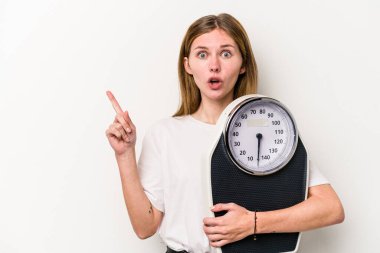 Beyaz arka planda izole edilmiş bir tartı tutan genç İngiliz kadın...
