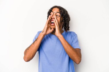 Beyaz arka planda izole edilmiş genç Afrikalı Amerikalı adam heyecanlı bir şekilde bağırıyor..