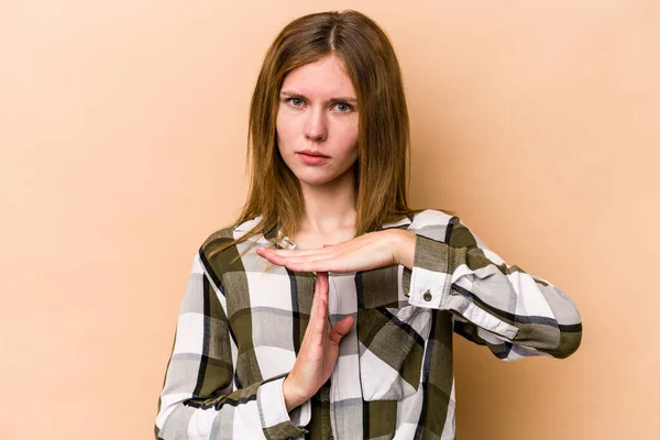 Young English woman isolated on beige background showing a timeout gesture.