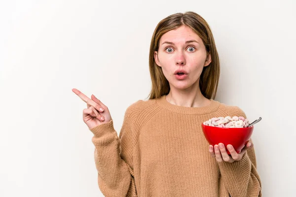 Jovem Inglesa Comendo Cereais Isolados Fundo Branco Apontando Para Lado — Fotografia de Stock