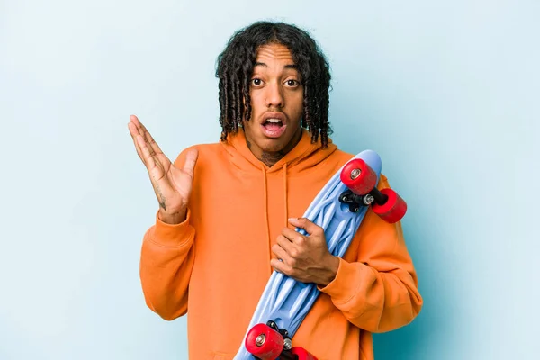 Junger Afroamerikanischer Skater Auf Blauem Hintergrund Isoliert Überrascht Und Schockiert — Stockfoto