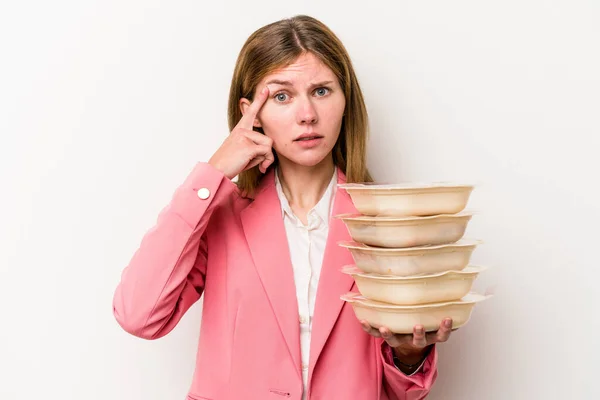 Young business English woman holding tupperware of food isolated on white background showing a disappointment gesture with forefinger.