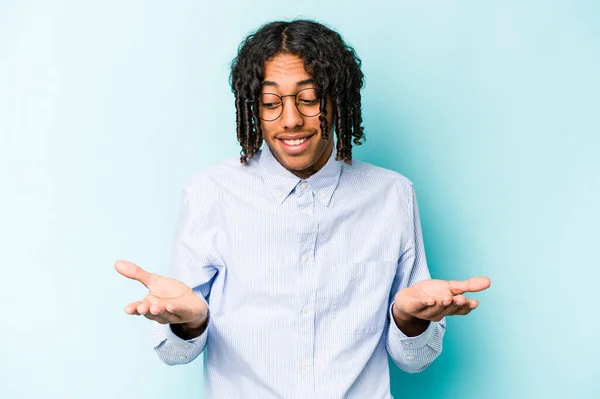 Giovane Uomo Afroamericano Isolato Sfondo Blu Con Mano Qualcosa Con — Foto Stock