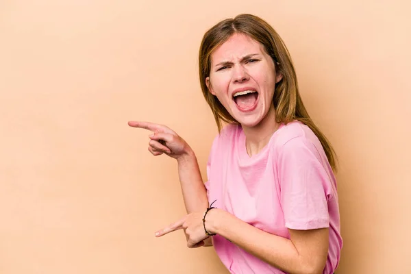 Junge Engländerin Isoliert Auf Beigem Hintergrund Und Zeigt Mit Den — Stockfoto