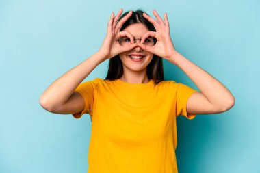 Mavi arka planda izole edilmiş beyaz bir kadın gözlerinde sorun olmadığını gösteriyor.