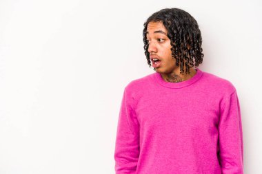 Genç Afro-Amerikalı bir adam beyaz arka planda izole edilmiş, gördüğü bir şey yüzünden şoka uğruyor..