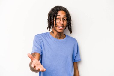 Beyaz arka planda izole edilmiş genç Afro-Amerikalı adam selamlaşma jesti olarak kameraya uzanıyor..