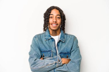 Beyaz arka planda izole edilmiş genç bir Afrikalı Amerikalı. Kendine güveniyor, kararlılıkla kollarını kavuşturuyor..