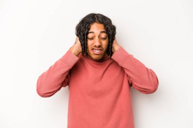 Genç Afrikalı Amerikalı adam beyaz arka planda izole edilmiş kulakları elleriyle kapatıyor..