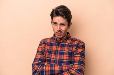 Bej arka planda izole edilmiş beyaz bir genç. Sıkılmış, yorgun ve dinlenmeye ihtiyacı var..