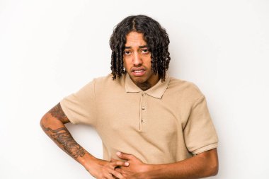 Beyaz arka planda karaciğer ağrısı ve karın ağrısı çeken genç bir Afrikalı Amerikalı..