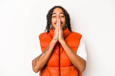 Beyaz arka planda izole edilmiş genç Afro-Amerikan bir adam el ele tutuşup dua ederken kendine güveniyor..