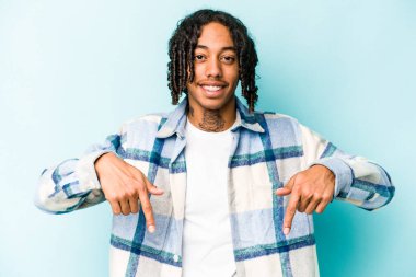 Genç Afrikalı Amerikalı adam mavi arka planda izole edilmiş. Parmakları aşağıda..