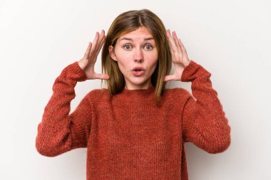 Beyaz arka planda zaferi ya da başarıyı kutlayan genç Rus kadın şaşırdı ve şok oldu..