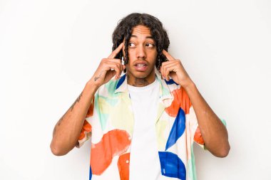 Genç Afrikalı Amerikalı bir adam beyaz arka planda izole edilmiş parmaklarıyla kulaklarını kapatan, yüksek sesli bir ortam tarafından stresli ve umutsuz..