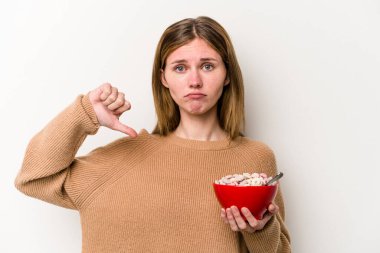 Beyaz arka planda izole edilmiş mısır gevreği yiyen genç bir İngiliz kadın hoş olmayan bir jest gösteriyor. Anlaşmazlık konsepti.