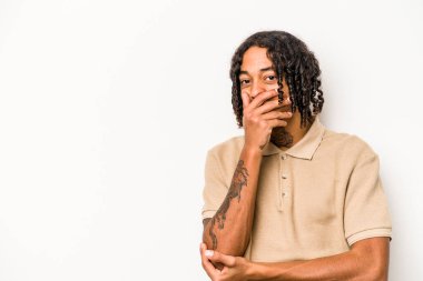 Genç Afro-Amerikan erkeği beyaz arka planda izole edilmiş mutlu, kaygısız, doğal duygulara gülüyor..