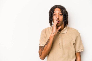 Beyaz arka planda izole edilmiş genç Afro-Amerikan bir adam gizli bir sıcak fren haberi veriyor ve kenara bakıyor.