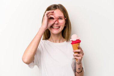 Beyaz arka planda izole edilmiş dondurma tutan genç bir İngiliz kadın heyecanlı..