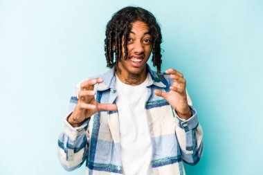 Genç Afrikalı Amerikalı adam mavi arka planda izole edilmiş öfkeyle bağırıyor..