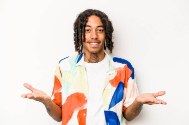 Beyaz arka planda izole edilmiş genç Afrikalı Amerikalı adam kollarıyla ölçek oluşturuyor, mutlu ve kendinden emin hissediyor..