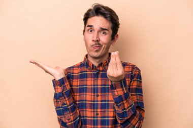 Beyazlı genç bir adam bej arka planda izole edilmiş..