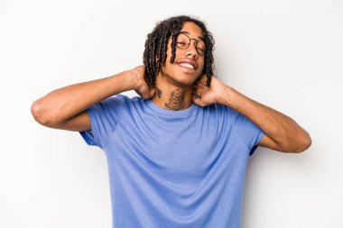 Genç Afrikalı Amerikalı bir adam beyaz arka planda izole edilmiş, kendinden emin, elleri başının arkasında..